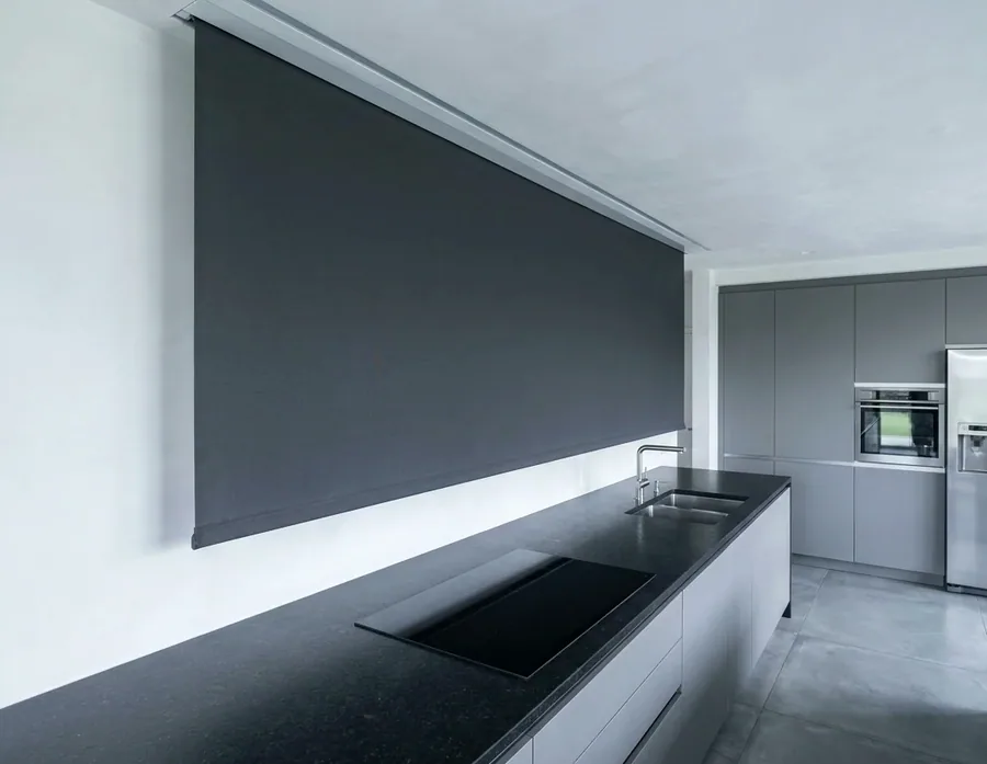 Blind dropping from a concealed ceiling recess over a long kitchen window in a Kyalami home